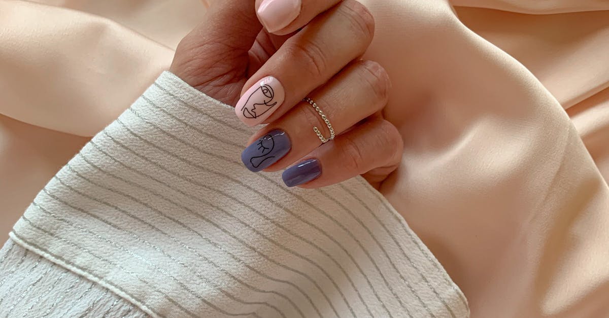 Close-up of a stylish, manicured hand with unique nail art, gracefully placed on pastel fabric. Perfect for style and beauty themes.